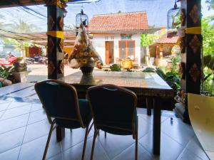 une table de salle à manger avec deux chaises devant une maison dans l'établissement The Semeton Homestay Senggigi RedPartner, à Montongbuwoh