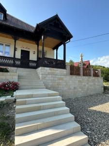 a house with stairs leading up to a building at Casă chic La Han la Slănic in Slănic-Moldova