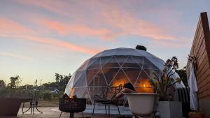 a woman sitting in a dome tent on a patio at Bespoke Dome Perfect for a Couples Getaway in Tasmania in Sidmouth