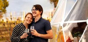Ein Mann und eine Frau posieren mit einem Weinglas für ein Foto. in der Unterkunft Incredible Dome Getaway on a Vineyard Perfect for Glamping, Tasmania in Sidmouth + 4 Fotos