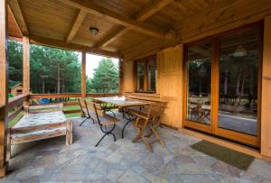 a patio with a table and chairs on a porch at Willa Pasym in Pasym