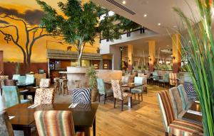 a restaurant with tables and chairs and a bar at Chessington Hotel in Chessington