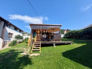 a gazebo with chairs and an umbrella in a yard at Casa David in Gura Hangului