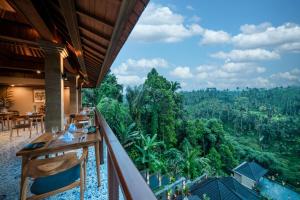 a balcony with a view of the jungle at Ellena Resort Tegallalang by Dhananjaya Hospitality in Tampaksiring