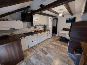 a kitchen with white cabinets and wooden floors at Casa David in Gura Hangului