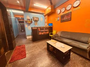 a living room with a couch and clocks on the wall at Sri Vinayaka Comforts in Narasimharaja Puram