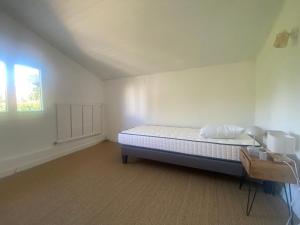 a white room with a bed and a window at Maison Gérard Philippe in Carcassonne