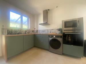 a kitchen with a washing machine and a microwave at Maison Gérard Philippe in Carcassonne