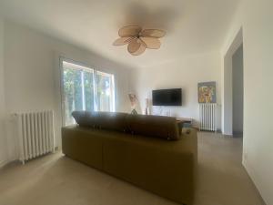 a living room with a couch and a ceiling fan at Maison Gérard Philippe in Carcassonne