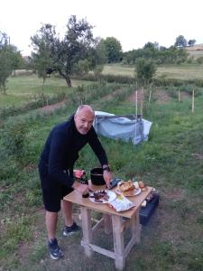 a man preparing food on a picnic table at Apartman Teodora Uvac in Nova Varoš +34 photos