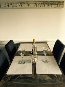 uma garrafa de vinho sentada numa mesa com copos em Tag am Meer Sylt II em Westerland