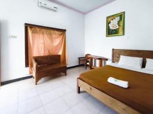 une chambre avec un lit, une chaise et une fenêtre dans l'établissement The Semeton Homestay Senggigi RedPartner, à Montongbuwoh