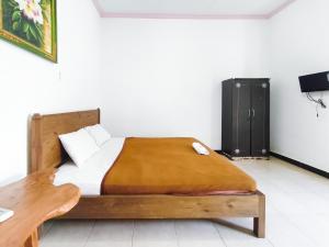 - une chambre avec un lit et une armoire noire dans l'établissement The Semeton Homestay Senggigi RedPartner, à Montongbuwoh