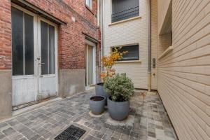 two plants in pots in front of a building at Studio COSY - 2P - Boulogne Billancourt in Boulogne-Billancourt