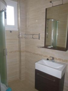 La salle de bains est pourvue d'un lavabo et d'une douche avec un miroir. dans l'établissement Paradisos House, à Skiathos Chora