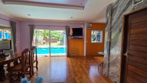 Una sala de estar con una mesa y un comedor. en Sky Blue Bungalows, en Phra Ae beach