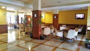 a restaurant with chairs and tables and a tv in a building at Europroperties Bendita Mare Apartments in Golden Sands