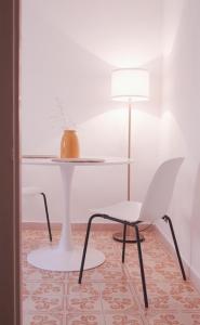 a white table and a white chair and a lamp at Tiny house at the heart of Le Madonie NP in Collesano