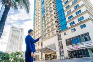 a man in a suit standing in front of a building at Astoria Plaza in Manila