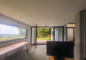 a living room with a tv and a large window at Casa Cotera in Sierra