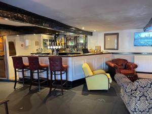 a bar in a room with chairs and a counter at Lake District Pub with 10 en-suite rooms in Hawkshead