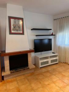 a living room with a television and a fireplace at Casa Bueno- Sleeps 7 Private Pool & AirCon in Los Llanos