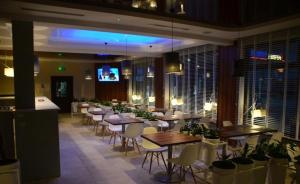 a restaurant with tables and chairs and a flat screen tv at Hotel Pauza in Radzyń Podlaski