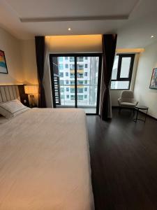 une chambre avec un grand lit et une grande fenêtre dans l'établissement SAPHIRE Hạ Long, à Hạ Long