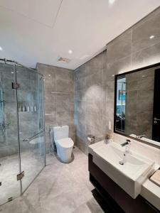 une salle de bain avec un lavabo, une douche et des toilettes dans l'établissement SAPHIRE Hạ Long, à Hạ Long