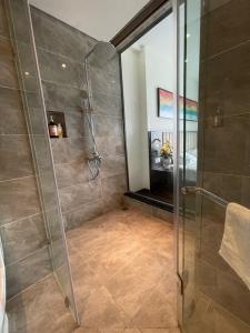 une douche avec une porte vitrée dans une salle de bain dans l'établissement SAPHIRE Hạ Long, à Hạ Long