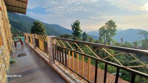a balcony of a house with a view of the mountains at Khimdung Mannat Homestay in Mangpu