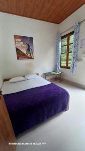 a bedroom with a bed with a purple blanket at Khimdung Mannat Homestay in Mangpu +15 photos