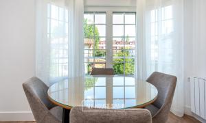 a dining room with a glass table and chairs at MyHouseSpain - Hermosa casa con jardín en Gijón in Gijón