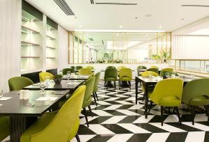 a dining room with tables and green chairs at Astoria Plaza in Manila