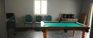 a room with a pool table and chairs at Villa avec piscine privée en Normandie in Saint-Clair-dʼArcey