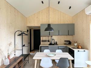 a kitchen with a table and white chairs at Lake Garden Villa in Sadžiūnai