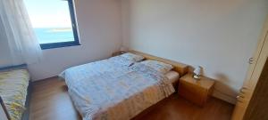 a small bedroom with a bed and a window at Sunset Zaglav Apartment in Martinšćica