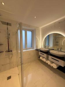 a large bathroom with two sinks and a shower at Au coeur du chaos in Huelgoat