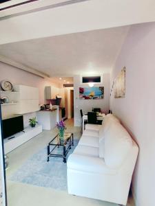 Una sala de estar con un sofá blanco y una mesa. en La Serena del Garda!, en Desenzano del Garda