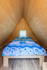 ゴレンスカ地方にあるGlamping Radovna pr' Klemenakの窓付きの木造キャビンのベッド1台分です。 +8枚の写真