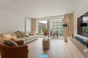 ein Wohnzimmer mit Couch und großem Fenster in der Unterkunft Newport 2 - Luxury apartment near the sea in Nieuwpoort Bad in Nieuwpoort