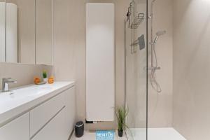 ein weißes Badezimmer mit Waschbecken und Dusche in der Unterkunft Newport 2 - Luxury apartment near the sea in Nieuwpoort Bad in Nieuwpoort + 15 Fotos