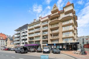 ein großes Gebäude, vor dem Autos parken in der Unterkunft Newport 2 - Luxury apartment near the sea in Nieuwpoort Bad in Nieuwpoort