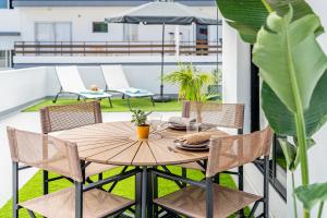 - une table en bois sur un balcon avec des chaises et un parasol dans l'établissement Splendid penthouse with terrace in the center of Puerto de la Cruz, à Puerto de la Cruz