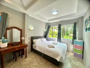 Un dormitorio con una cama y un escritorio y una ventana. en Sky Blue Bungalows, en Phra Ae beach 23 fotos más