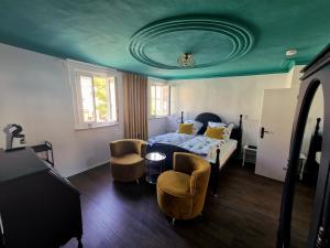 a bedroom with a bed with a blue ceiling at Hotel Schief & Schön in Kitzingen
