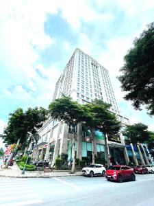 Un gran edificio blanco con coches aparcados delante. en Golden King, en Ho Chi Minh