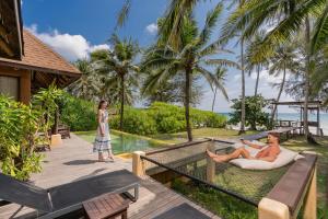 two women on the deck of a resort with a pool at High Season Pool Villa & Spa in Ko Kood