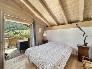 Un dormitorio con una cama y una ventana grande. en ELI422 Appartement standing 6 pers centre village, en Les Carroz d'Araches