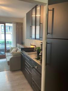 a kitchen with a stainless steel refrigerator and a couch at Studio terrasse in Middelkerke